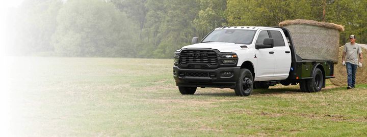 Ram chassis cab with a flatbed body loaded on a working field